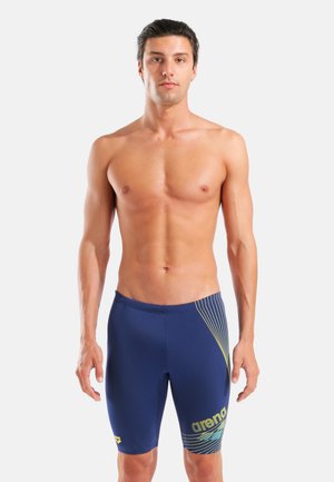 Marineblaue Badeshorts mit figurbetontem Design, aus elastischem Material gefertigt, mit gelben Akzentlinien und Logo am linken Oberschenkel.