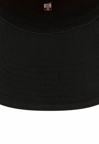 Schwarzer Baumwoll-Bucket-Hut mit strukturiertem Rand, gesteppten Details und einem Innenetikett. Glatte Textur ohne sichtbare Muster oder Akzente.