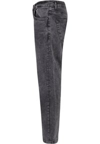 Feszes szabású farmer, elhalványult fekete denim anyagból. Öt zseb, övhurkok és egyenes szár jellemzi. Az anyag sima tapintású, minimális kopással.