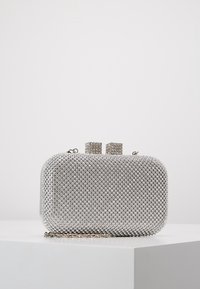 Clutch metálico plateado con una superficie texturizada de strass, forma rectangular y cadena strap. Dos acentos de hardware cuadrados en la parte superior.