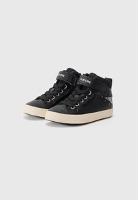 Svarte høye sneakers med en blank overflate, snøring og borrelås, som har et dekorativt glitterpanel på siden og gummisåle.