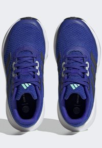 Scarpe da ginnastica viola con tomaia in rete, accenti neri, lacci piatti e suola bianca ammortizzata. Presentano un logo sulla linguetta.