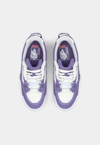 Zapatillas Vans moradas y blancas con parte superior texturizada, diseño de cordones, cuello acolchado y suela de goma. Presenta el logo en la lengüeta y el panel lateral.