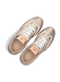 Sneakers met een textuur van metallic goud en cream bovenwerk, witte veters en een subtiele logo op de tong; platte rubberen zool.