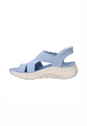 Light blue open-toe sandal with knit upper, cushioned white sole, and elastic back strap for support and comfort.
