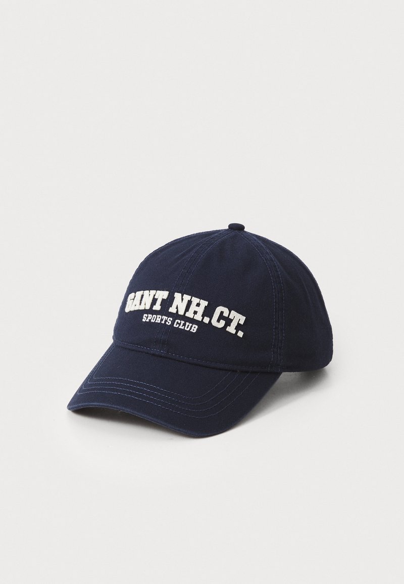 Navy blue baseball cap made of cotton with a curved visor. Features white embroidered text reading "GANT NH CT. SPORTS CLUB." Plain design.
