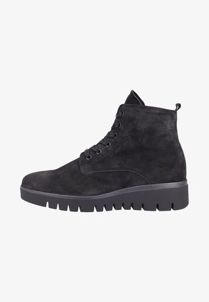Zwarte suède enkelboots met een dikke, gestructureerde zool, voorzien van ronde vetersluiting en een trekband aan de achterkant voor gemakkelijk aan- en uittrekken.