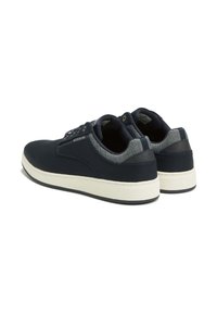 Sneaker blu navy con tomaia in tessuto liscio, suola in gomma bianca a contrasto e dettagli in rete sul tallone. Presenta lacci e dettagli con logo.