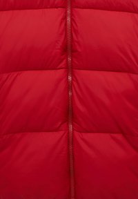 Červená nafukovací bunda s vertikálním zipem, prošívaným designem s horizontálními švy a hladkou, lesklou texturou látky.