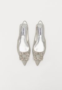 Chaussures à talons slingback en argent pailleté avec des orteils pointus, présentant une boucle en rhinestone décorative sur le devant et une semelle intérieure métallique élégante.