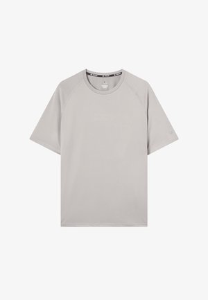 Lichtgrijs sport t-shirt met korte mouwen en ronde hals, subtiel logo op de borst en mouw, en merklabel aan de binnenkant van de kraag.