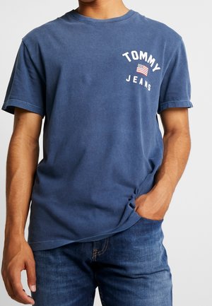 T-shirt en coton bleu marine à manches courtes, col rond, avec le texte blanc « TOMMY JEANS » et un graphisme du drapeau américain. Coupe standard.