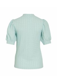Blusa azzurro chiaro con texture, maniche corte a sbuffo e scollatura tonda. Il tessuto presenta un delicato motivo a quadretti.