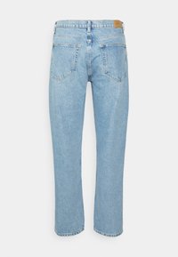 Lys blå denimjeans med lige pasform, fem lommer og en mid-rise talje. Stoffet har en let slidt finish.