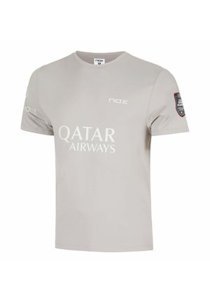 Maglietta sportiva grigio chiaro a maniche corte con i loghi "Qatar Airways" e "nox" sul davanti e una toppa nera e rossa sulla manica destra.