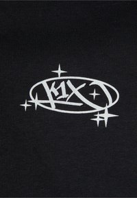 Tissu noir avec un logo blanc audacieux. Le logo comprend un texte stylisé et des accents d'étoiles, sur une surface lisse et uniforme.