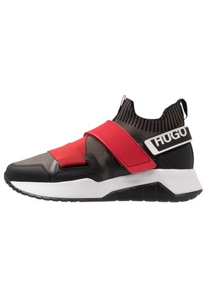 Strømpe-stil sneaker i sort og grå med røde elastiske stropper og hvid sål, med "HUGO" branding på hælstrop.