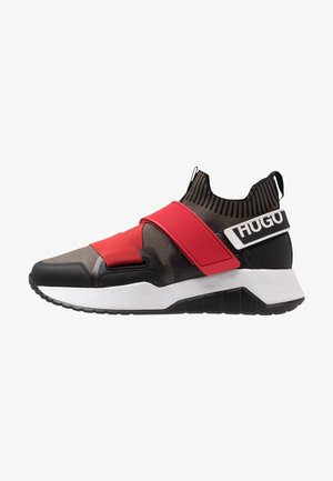 Baskets style chaussette en noir et gris avec des bandes élastiques rouges et une semelle blanche, avec le logo "HUGO" sur la bride du talon.