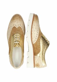 Chaussures en cuir doré et en daim beige avec un design brogue, présentant des accents texturés, une semelle en caoutchouc blanche et des lacets contrastants.