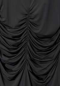 Tissu noir avec une texture froncée, présentant des détails de ruchés prononcés qui créent des lignes verticales et un drapé doux sur la surface.