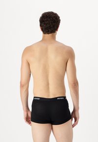 Boxer in nero con vita elastica che presenta il logo "HUGO". Realizzati in materiale comodo e elastico, design attillato senza motivi visibili.