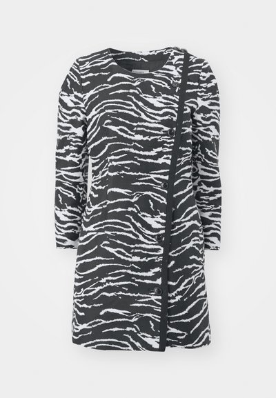 Black and white zebra-print dress with long sleeves, round neckline, and side buttons. Features a textured fabric and asymmetrical design.