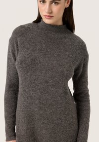 Maglione grigio a maniche lunghe in knit con colletto alto, caratterizzato da una consistenza morbida e dettagli minimi. Design slim fit con lieve elasticità.
