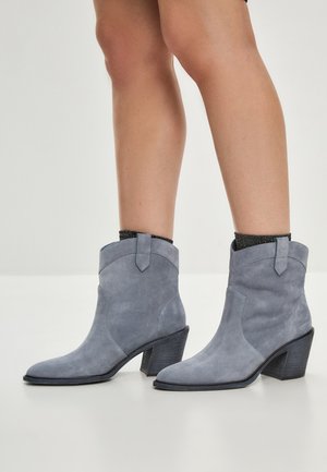Bottes de cheville en daim gris avec un léger talon, dotées d'un bout arrondi, d'accents latéraux et d'une texture lisse. Conviennent à diverses tenues.