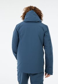 Blå vandtæt jakke med hætte, der har en glat tekstur og sømløs skulderdesign. Inkluderer lynlåslommer og justerbare manchetter.