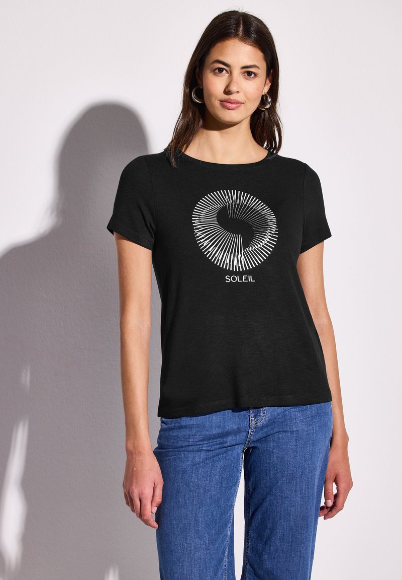 T-shirt noir à manches courtes avec un motif graphique circulaire blanc et le mot "SOLEIL" imprimé en dessous. Tissu simple et léger.