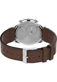 Brauner Lederuhrarmband mit einem Gehäuse aus silbernem Edelstahl. Die Rückseite weist eine glatte, polierte Oberfläche und eine runde Vertiefung für den Zugang zur Batterie auf.