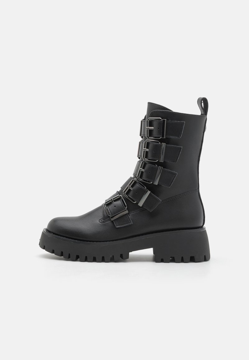 Black ankle boots made of leather, featuring multiple metal buckles, a thick platform sole, and a pull tab at the back.