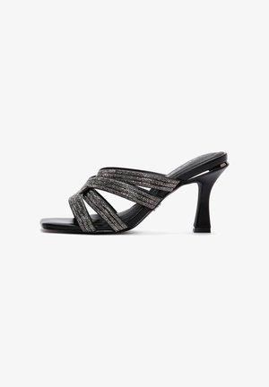 Sandale à talon haut noire à brides multiples scintillantes croisant le pied, avec un talon fin et courbé.