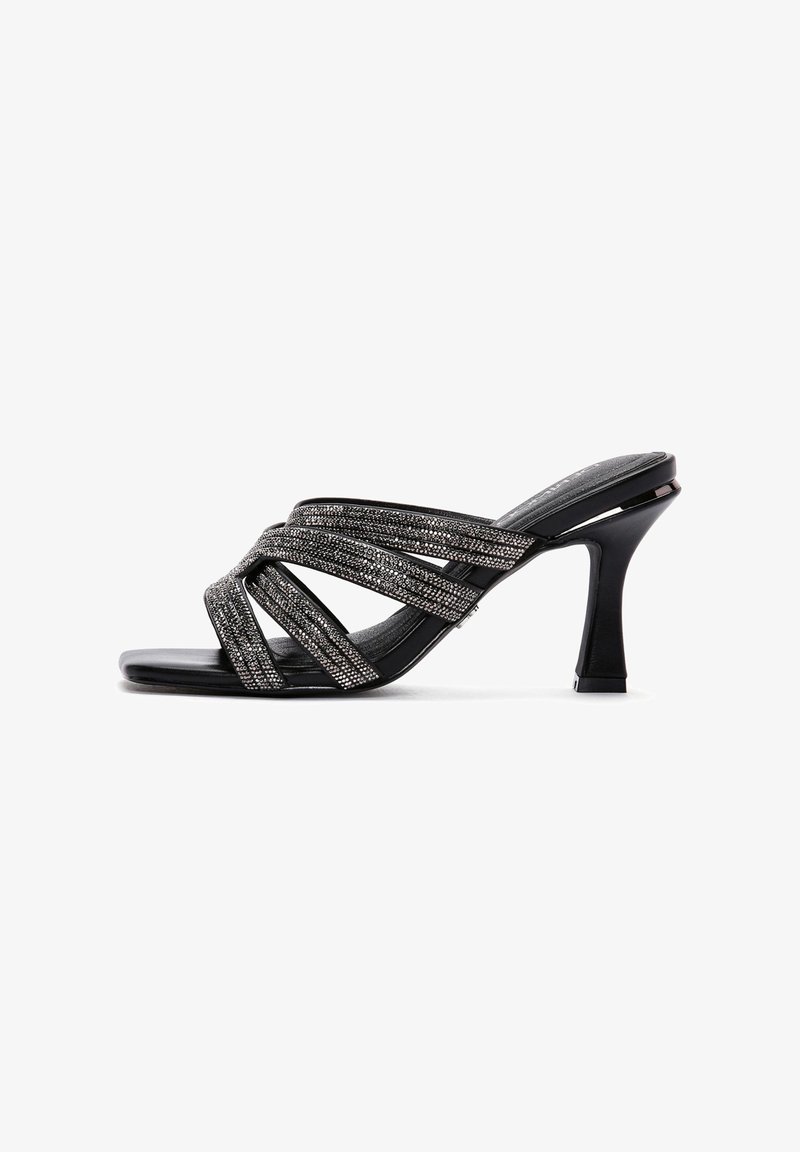 Sandale à talon haut noire à brides multiples scintillantes croisant le pied, avec un talon fin et courbé.
