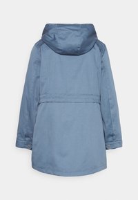 Niebieska bluza z kapturem, wykonana z miękkiego materiału, o prostym kroju, średniej długości z zapięciem na guziki przy mankietach.