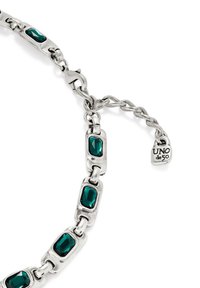 Pulsera de cadena plateada con piedras preciosas rectangulares verdes, eslabones pulidos alternados y una placa distintiva con la inscripción "UNO de 50".