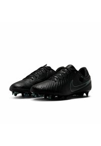 Black soccer cleats featuring a textured leather upper, rounded toe, and prominent Nike swoosh in dark green. Studded outsole for traction.