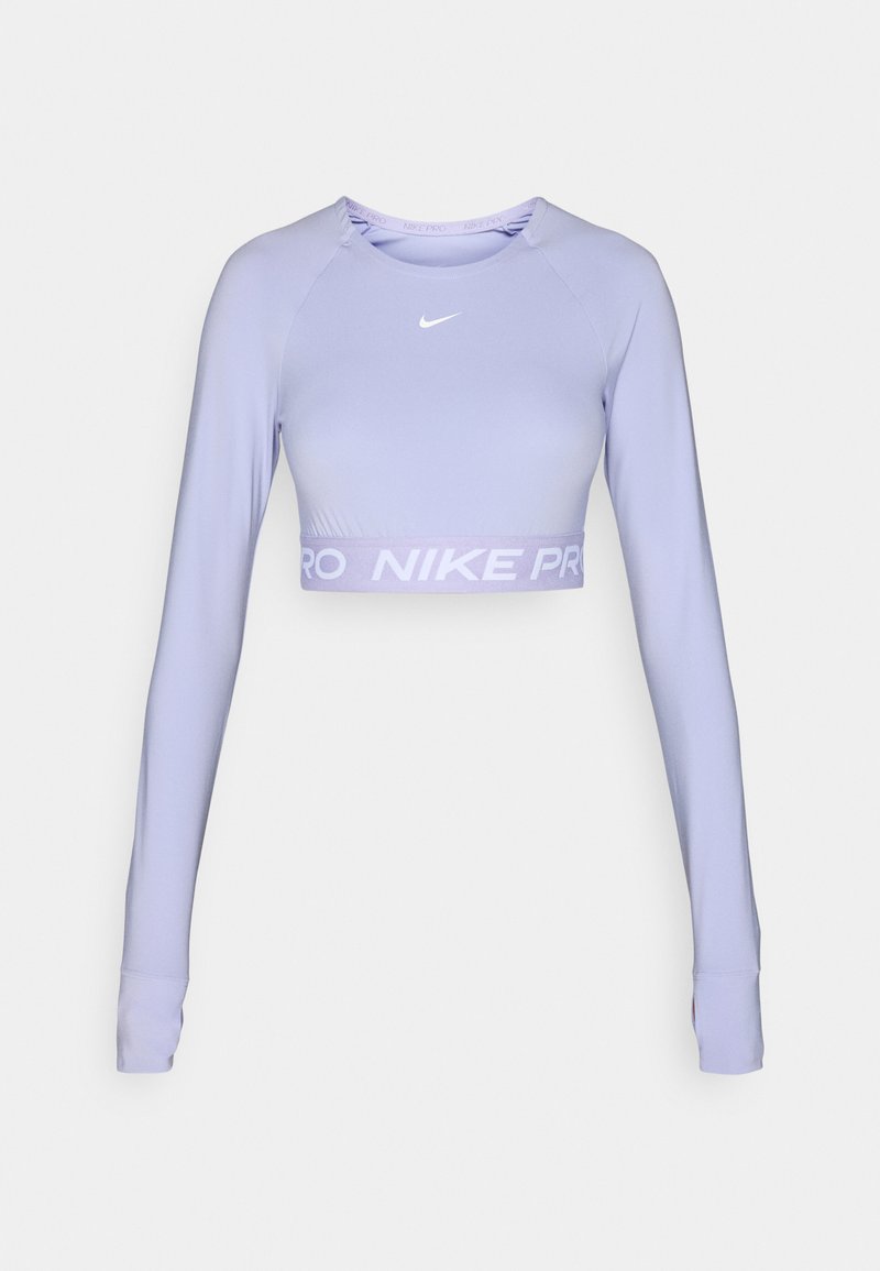 Top corto de manga larga en color lila, hecho de una tela suave y flexible, que presenta un logo de Nike en blanco y una cinturilla ancha de color púrpura claro con la marca.