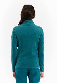 Teal fleece jack met een hoge kraag en lange mouwen, met een gladde textuur en een slim fit ontwerp. Geen zichtbare branding of patronen.