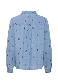 Camicia in denim azzurro chiaro con colletto arricciato, maniche lunghe e motivi floreali blu navy. Polsini con bottoni e dettagli con piega sul retro.