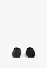 Scarpe nere basse in tessuto testurizzato con fodera morbida. Punta arrotondata e profilo basso. Nessun hardware o dettaglio visibile.