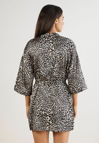 Leopardstribet kimono i let stof, med trekvart ærmer, belted talje og en kant der falder midt på låret.