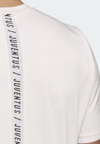 Witte katoenen T-shirt met een zwart geweven label met "JUVENTUS" aan de achterkant. Korte mouwen en een klassiek ronde hals ontwerp.