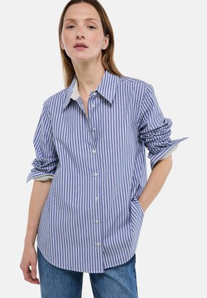 Chemise à rayures bleu et blanc, coupe décontractée, avec une patte de boutonnage devant, des poignets repliés et un ourlet arrondi. Le tissu semble léger.