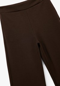 Bruna tights med hög midja och slät textur, designade för komfort med en kroppsnära passform och inga synliga sömmar.