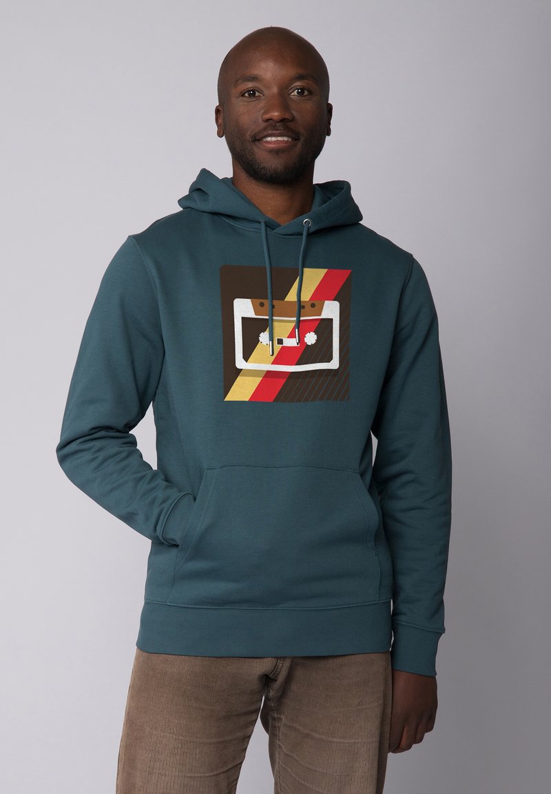 Türkise Kapuzenpullover mit Fronttasche und Grafikdruck eines Kassetten-Designs mit roten, gelben und braunen Streifen.