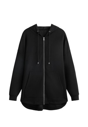 Svart zip-up huvtröja, bomullstyg, oversized design, justerbar dragsko i huvan, två framfickor, rundad nederkant, mjuk textur.