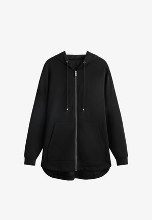 Crna zip-up dukserica, pamučni materijal, oversized dizajn, podesiva kapuljača sa vezicama, dva prednja džepa, zaobljen rub, glatka tekstura.