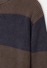 Gros plan sur un tissu de pull en tricot rayé marron et bleu foncé montrant le détail de la texture des points et le contraste des couleurs.