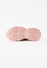 Rózsaszín gumitalpú sneaker, amely különböző szegmensekből áll, texturált zigzag mintával és lekerekített szélekkel rendelkezik, hogy fokozza a tapadást.